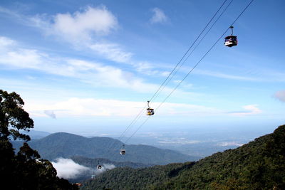 Low angle view of overhead cable car against sky