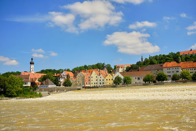 Houses by sea against sky