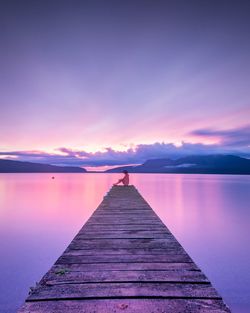 Pier on lake at sunset