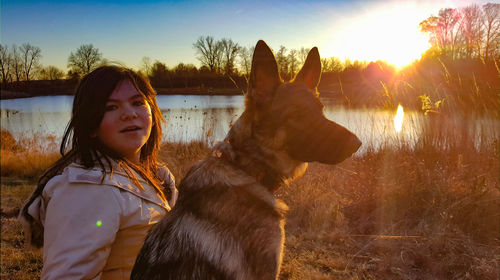 Young man with horse standing on field during sunset