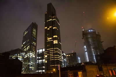 Low angle view of illuminated buildings against sky at night