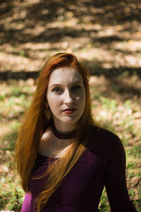 Portrait of young woman sitting in park