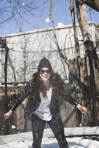 Happy young woman playing in the snow