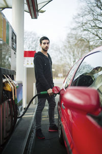 Portrait of man refueling car at gas station