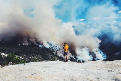 Man standing on landscape against volcano