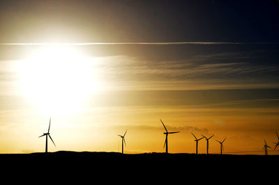 Silhouette of wind turbines at sunset