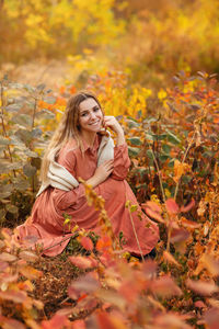 Portrait of smiling young woman with autumn leaves