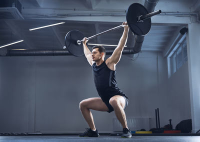 Man doing barbell exercise at gym during weight lifting workout