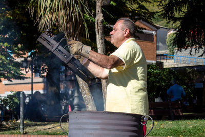 Side view of man holding umbrella in yard