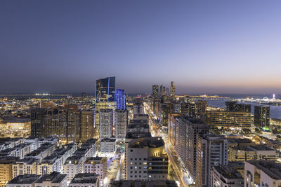 High angle view of illuminated buildings against clear sky at night