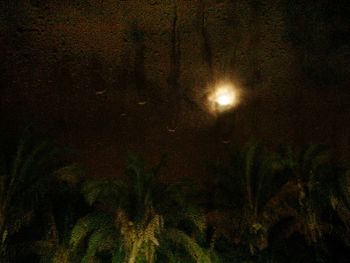 Low angle view of illuminated lights against sky at night