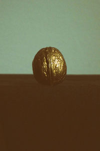 Close-up of apple on table against wall