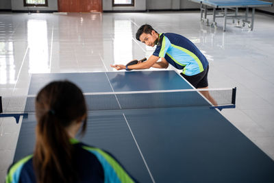 Side view of boy playing tennis