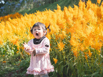 Portrait of cute girl standing against plants