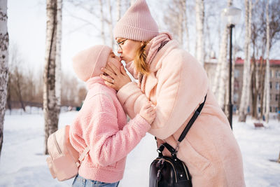 Mother and daughter happily embrace spring walk in the park sunny day