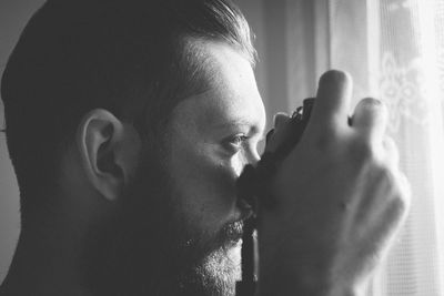 Close-up of mid adult man photographing through camera