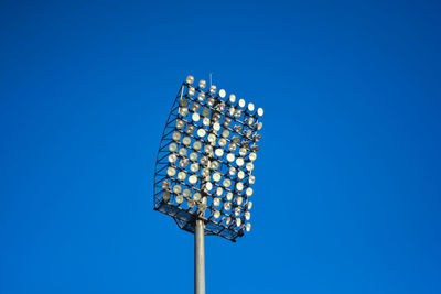 Low angle view of illuminated lamp against blue sky