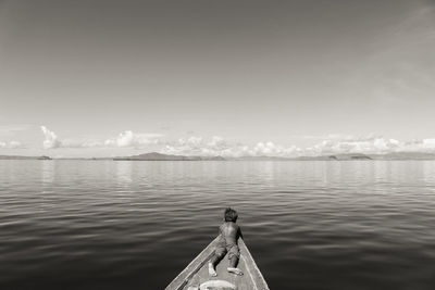 Rear view of man on sea against sky