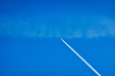 Low angle view of vapor trail against blue sky