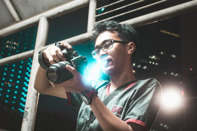 Portrait of young man holding camera