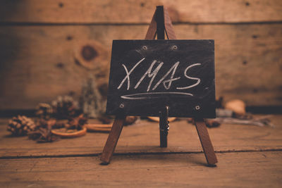 Close-up of text on wooden table against wall