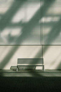 Empty bench against built structure
