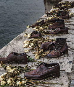 Abandoned shoes and flowers on promenade by sea