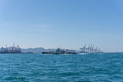 Sailboats in sea against blue sky