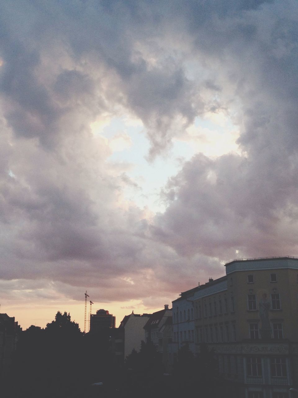 building exterior, architecture, built structure, sky, sunset, cloud - sky, silhouette, cloudy, city, residential structure, residential building, low angle view, building, house, cloud, weather, outdoors, overcast, dusk, no people