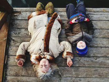 High angle view of people lying on wood