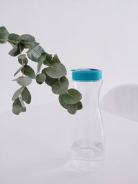 Close-up of green bottle in water against white background