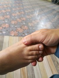 Cropped hand of person holding child foot