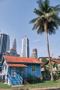 Overall view of old wooden houses with modern buildings in the background in kuala lumpur malaysia.