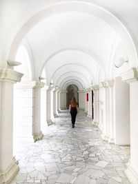 Rear view of woman walking in corridor