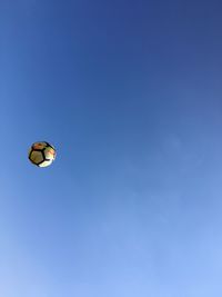 Low angle view of hot air balloon against blue sky