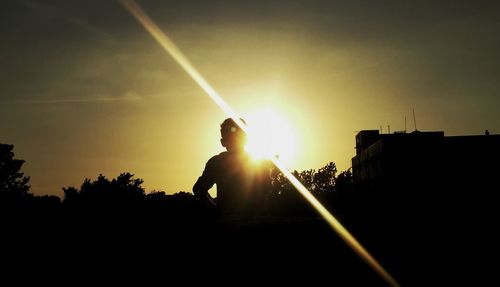 Silhouette man against sun during sunset