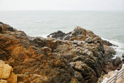 Photo of some weathered eroded cracked rocks on the coastline