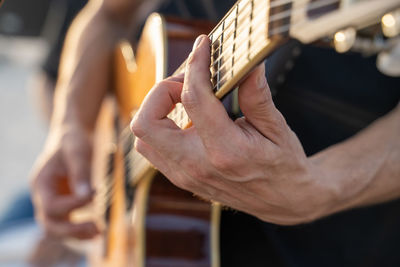 Cropped hand of man playing guitar