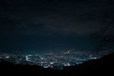 Illuminated cityscape against sky at night
