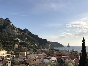 Village by sea against sky in corfu island greece 