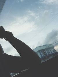 Close-up of hand on airplane against sky