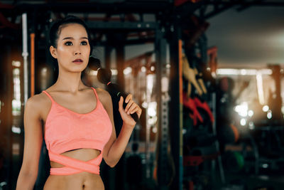 Midsection of woman standing against illuminated store