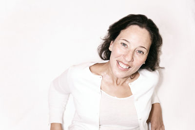 Portrait of a smiling young woman against white background