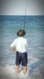 Rear view of a man standing on beach