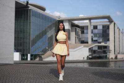 Full length of young woman standing in city