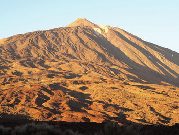 Scenic view of snowcapped mountains and vulcano against clear sky