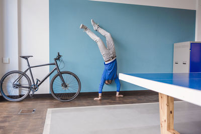 Man doing a handstand in break room of modern office
