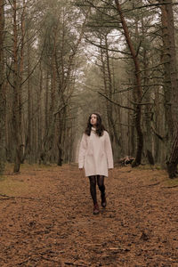 Portrait of young woman standing in forest