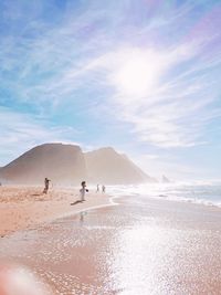 Group of people on beach against sky