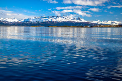 Scenic view of sea and mountains against sky during winter